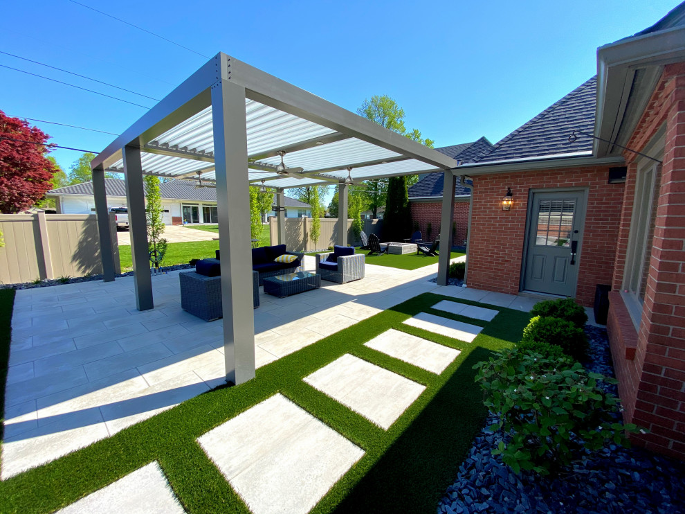 Esempio di un grande patio o portico moderno dietro casa con un focolare, pavimentazioni in cemento e una pergola