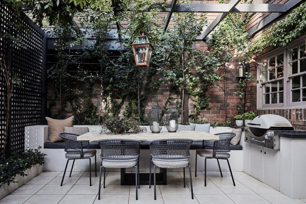 Photo of a farmhouse courtyard patio in Sydney with an outdoor kitchen, tiled flooring and a pergola.