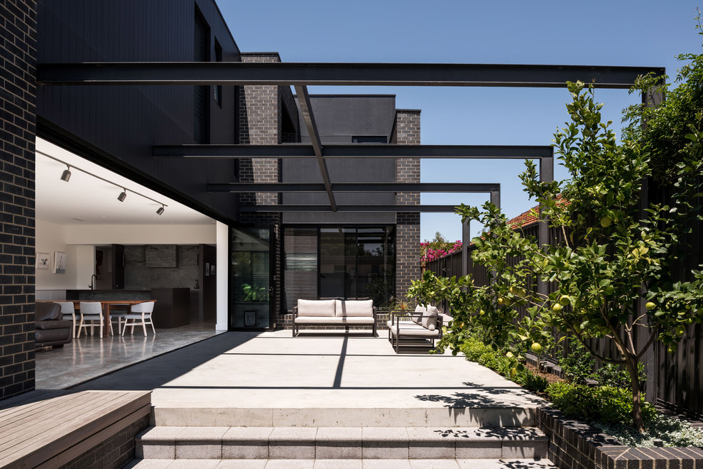 Idee per un patio o portico design nel cortile laterale con lastre di cemento e una pergola