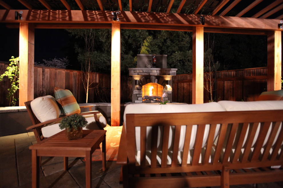 Photo of a large traditional back patio in San Francisco with a fire feature, natural stone paving and a pergola.
