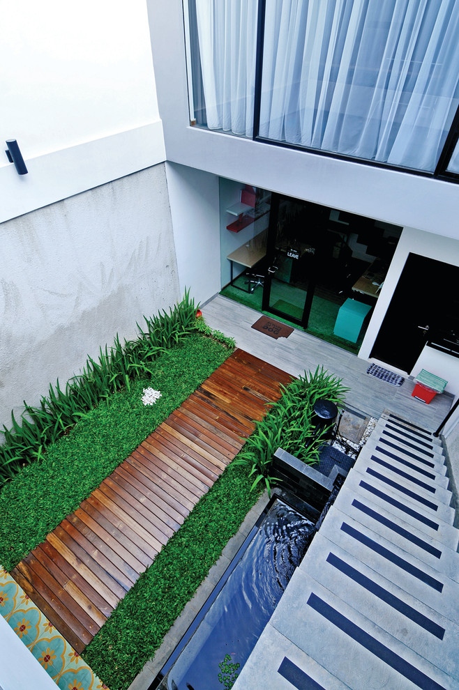На фото: двор среднего размера на внутреннем дворе в современном стиле с фонтаном и настилом без защиты от солнца
