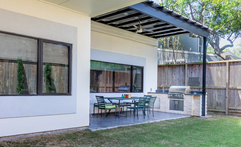 Стильный дизайн: двор среднего размера на заднем дворе в современном стиле с летней кухней, покрытием из бетонных плит и козырьком - последний тренд