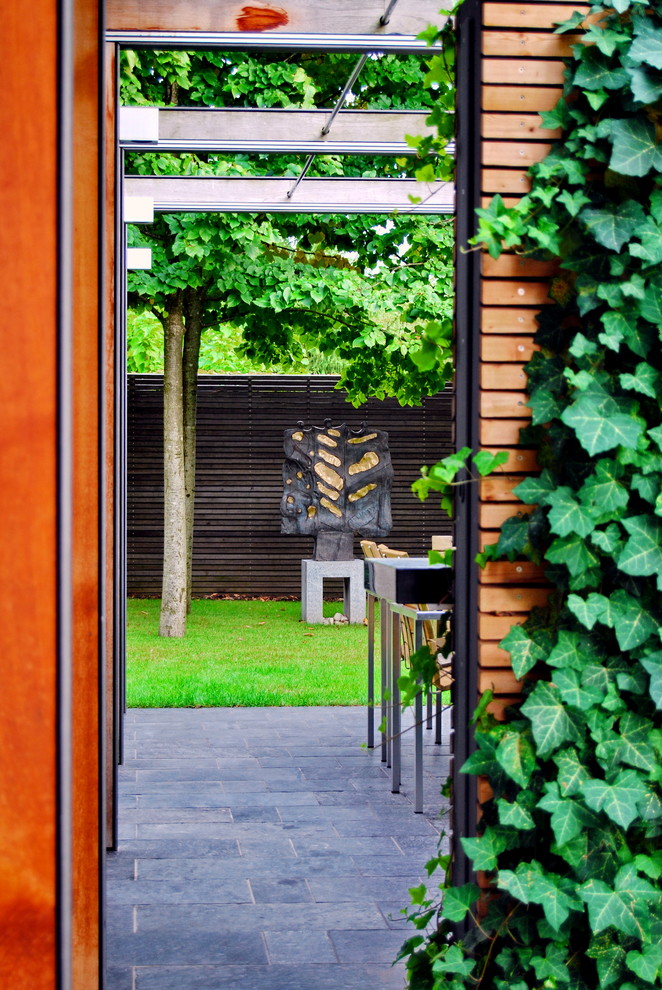 Свежая идея для дизайна: большая пергола во дворе частного дома на внутреннем дворе в стиле модернизм с вертикальным садом и покрытием из каменной брусчатки - отличное фото интерьера