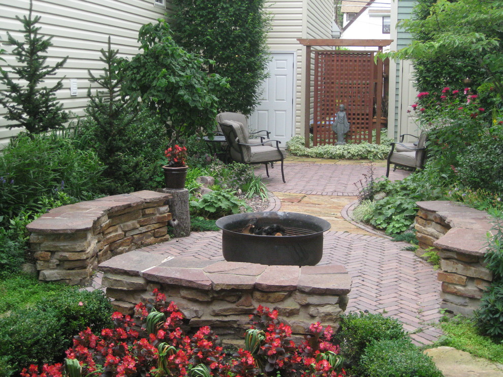 Patio - mid-sized traditional backyard brick patio idea in Chicago with a fire pit and no cover
