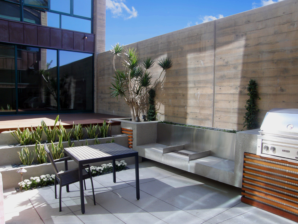 This is an example of a large modern back patio in San Diego with an outdoor kitchen, tiled flooring and no cover.
