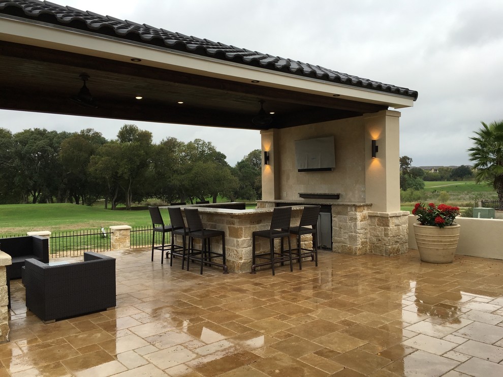 Großer Mediterraner Patio hinter dem Haus mit Outdoor-Küche, Natursteinplatten und Gazebo in Austin