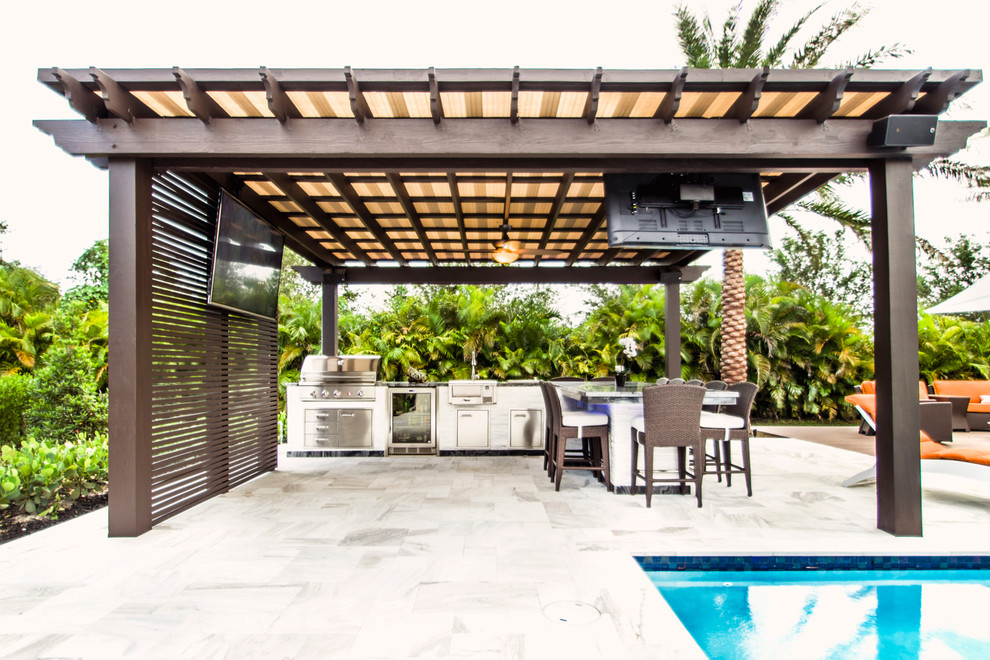 Foto di un grande patio o portico minimal dietro casa con una pergola e pavimentazioni in pietra naturale