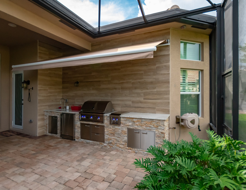 Foto di un patio o portico tradizionale dietro casa con pavimentazioni in mattoni e un parasole
