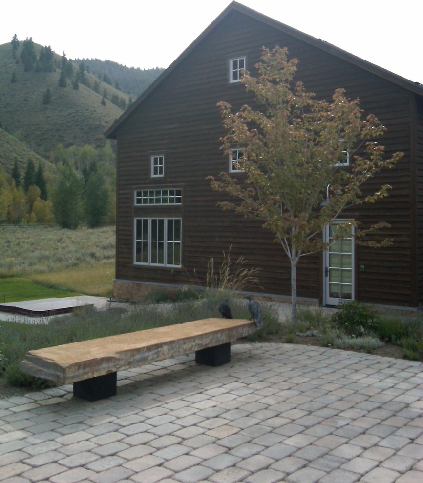 Photo of an expansive rural back patio in Boise with a water feature, natural stone paving and no cover.