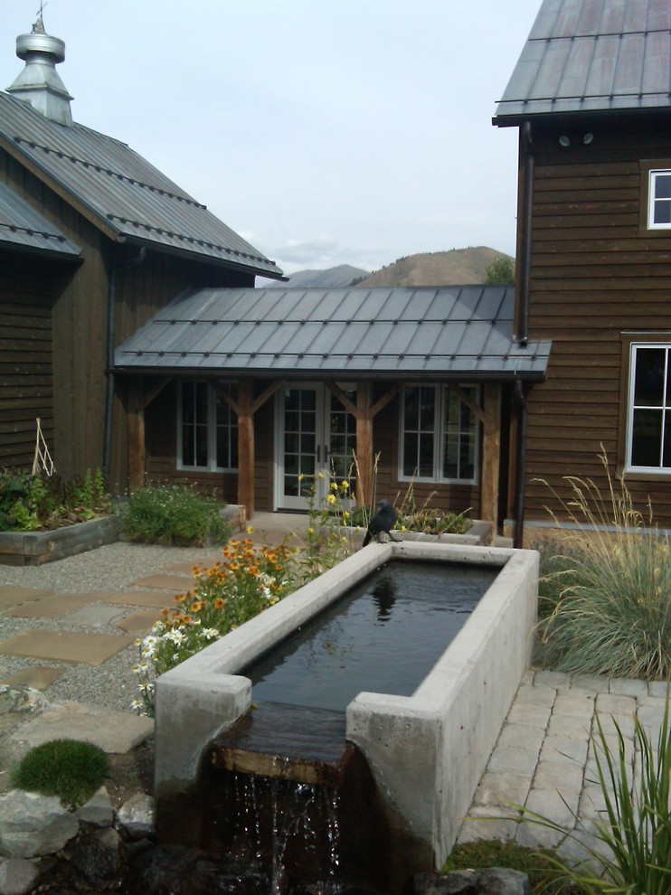 Idee per un ampio patio o portico country in cortile con fontane, pavimentazioni in pietra naturale e un tetto a sbalzo