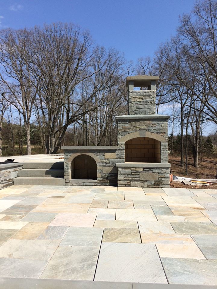 Inspiration for a large timeless backyard stone patio remodel in New York with a fire pit