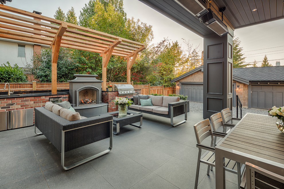 Inspiration for a large modern back patio in Vancouver with an outdoor kitchen and a pergola.