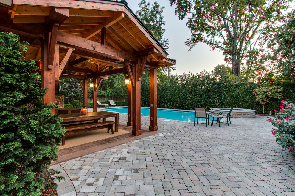 Example of a large mountain style backyard brick patio design in Nashville with a fire pit and a pergola