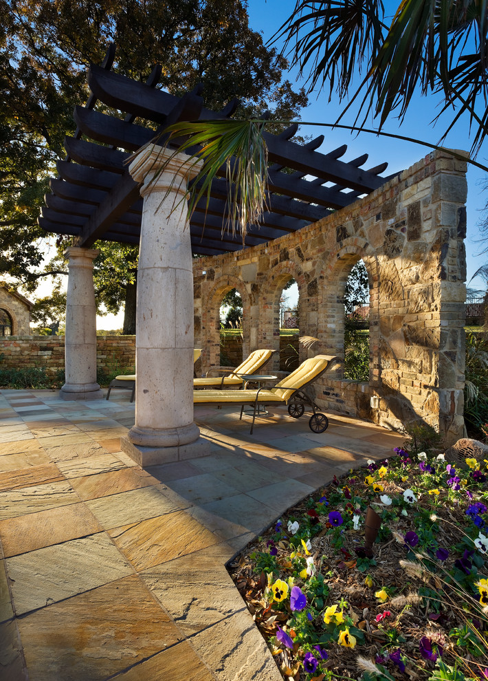 Imagen de patio mediterráneo con adoquines de piedra natural y pérgola