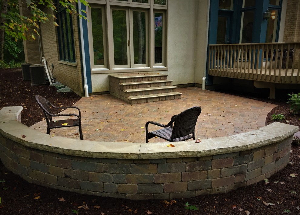 Immagine di un piccolo patio o portico classico dietro casa con un focolare, pavimentazioni in mattoni e nessuna copertura
