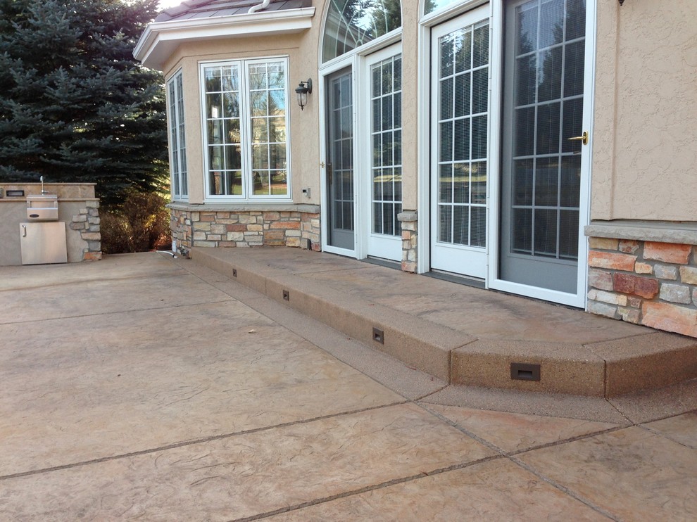 Inspiration for a large contemporary backyard stamped concrete patio remodel in Denver with no cover