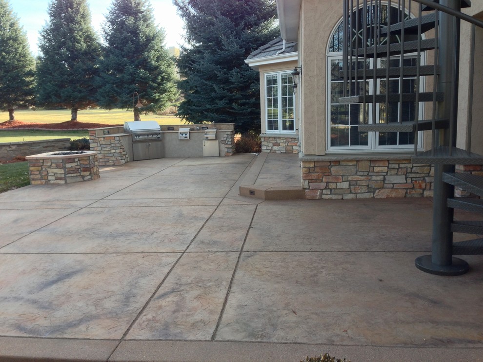 Patio - large contemporary backyard stamped concrete patio idea in Denver with no cover