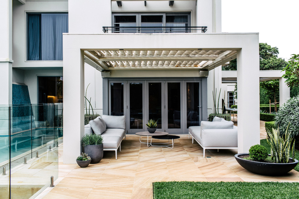 Großer Moderner Patio hinter dem Haus mit Kübelpflanzen und Natursteinplatten in Sydney