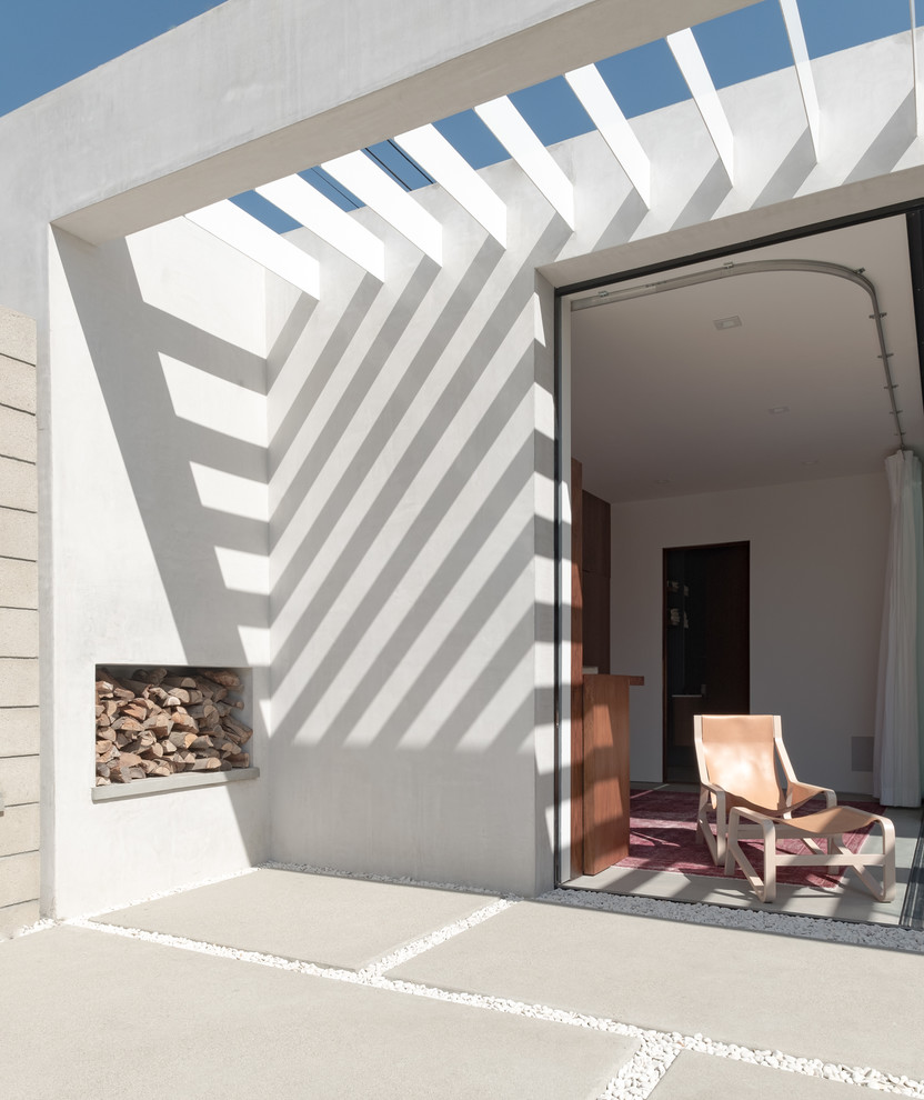 На фото: пергола во дворе частного дома в стиле модернизм с покрытием из бетонных плит с