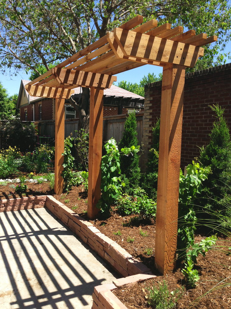 Example of a mid-sized classic backyard stone patio design in Denver with a pergola