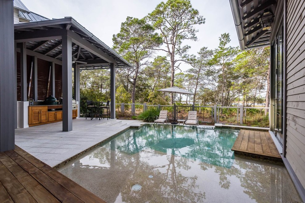 Diseño de piscina clásica renovada grande en patio trasero con entablado
