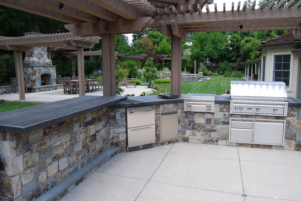 Inspiration pour une très grande terrasse arrière craftsman avec une cuisine d'été, du béton estampé et une pergola.