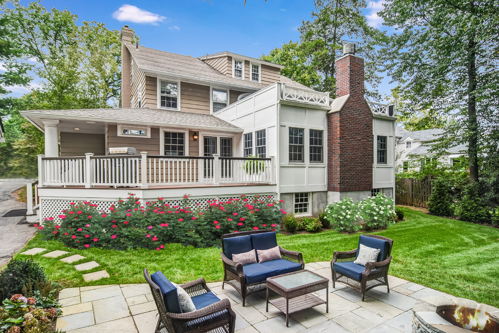 Large elegant backyard stone patio photo in New York with a fire pit and no cover