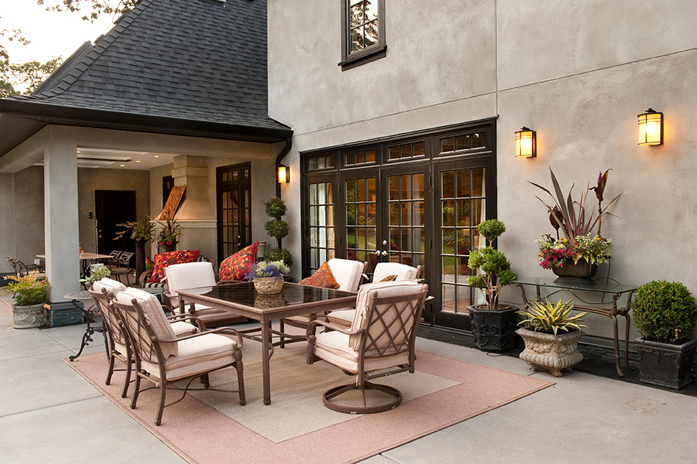 Idée de décoration pour une grande terrasse arrière tradition avec un foyer extérieur, des pavés en béton et une extension de toiture.