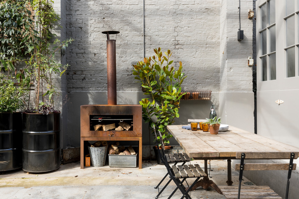Unbedeckter Industrial Patio im Innenhof mit Kübelpflanzen und Betonplatten in London