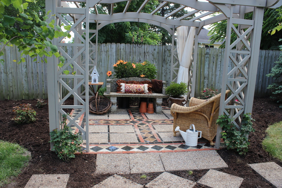 Imagen de patio clásico grande en patio trasero con adoquines de piedra natural