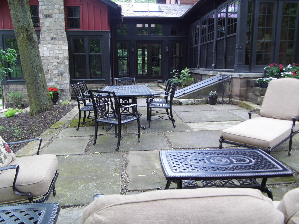 Пример оригинального дизайна: большой двор на заднем дворе в викторианском стиле с растениями в контейнерах и покрытием из каменной брусчатки без защиты от солнца