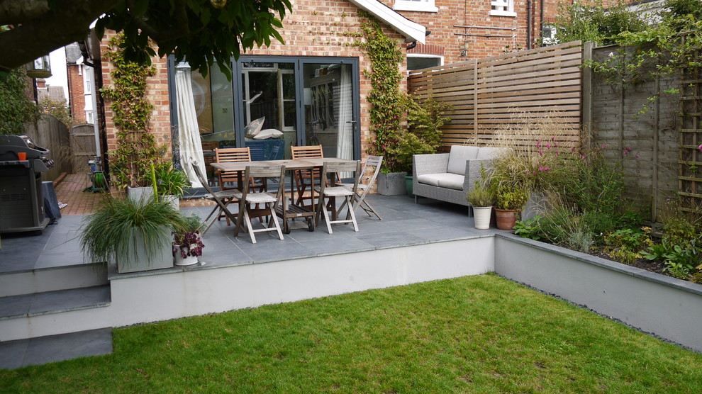Foto de patio contemporáneo pequeño en patio trasero con adoquines de piedra natural
