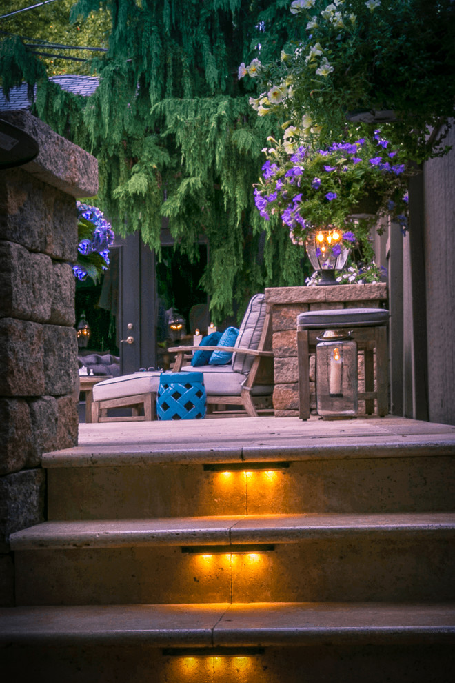 Foto di un piccolo patio o portico vittoriano dietro casa con un focolare, pavimentazioni in pietra naturale e un parasole
