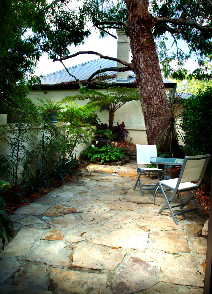 Moderner Patio hinter dem Haus mit Wasserspiel und Natursteinplatten in Sydney