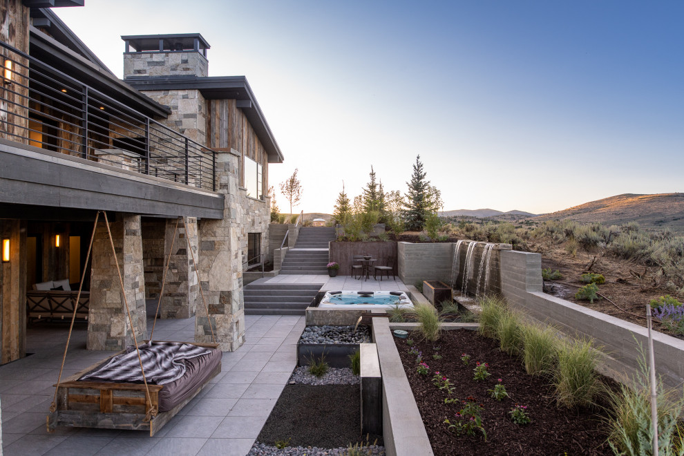 Large trendy backyard concrete patio fountain photo in Salt Lake City with a roof extension