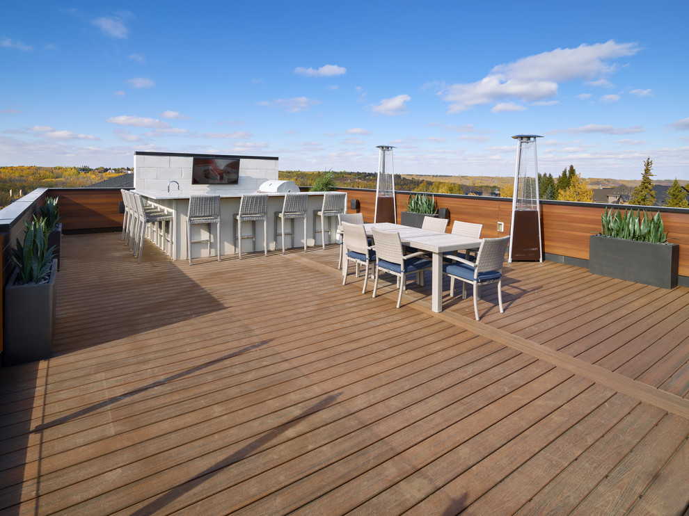 Inspiration for a large contemporary side yard patio kitchen remodel in Edmonton with decking and no cover
