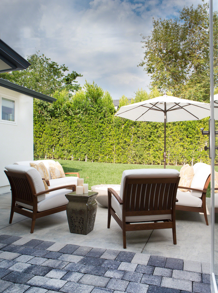 Foto de patio clásico renovado de tamaño medio sin cubierta en patio trasero con brasero y losas de hormigón