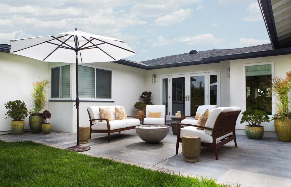 Inspiration for a medium sized classic back patio in Los Angeles with a fire feature, concrete slabs and no cover.