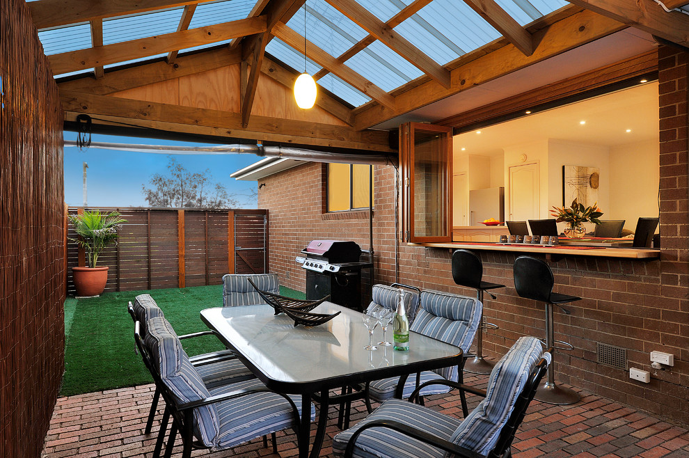 Example of a small minimalist side yard brick patio design in Melbourne with a pergola