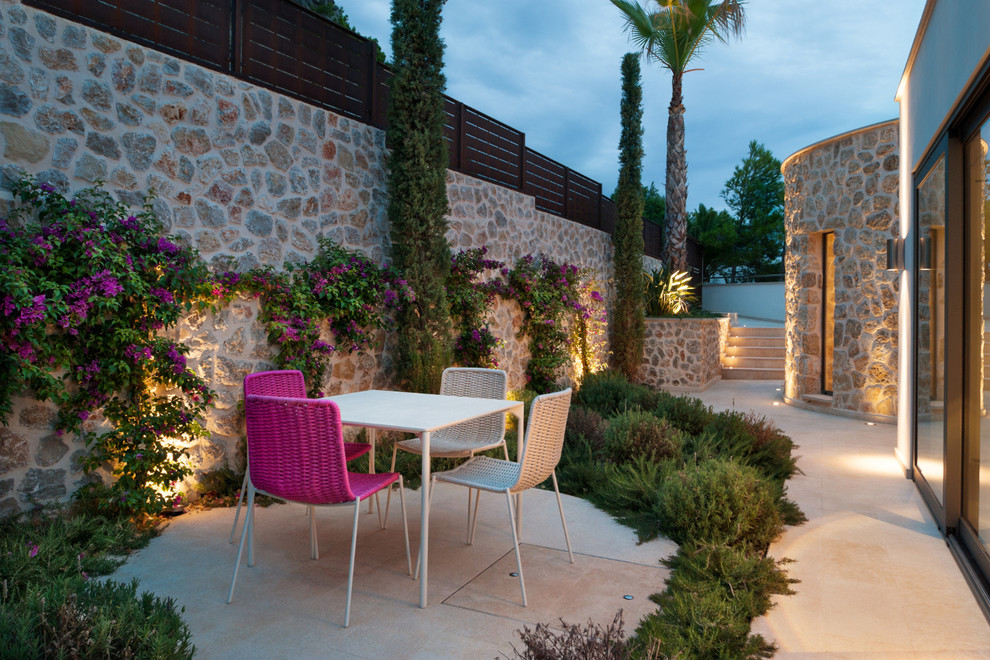 Imagen de patio costero de tamaño medio sin cubierta en patio lateral con adoquines de piedra natural