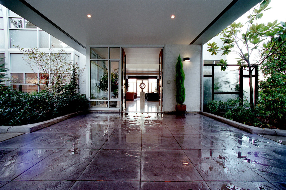 Идея дизайна: большой двор на внутреннем дворе в стиле модернизм с покрытием из каменной брусчатки и навесом