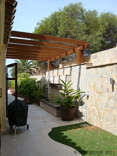 Imagen de patio actual de tamaño medio en patio lateral con adoquines de piedra natural, cenador y fuente