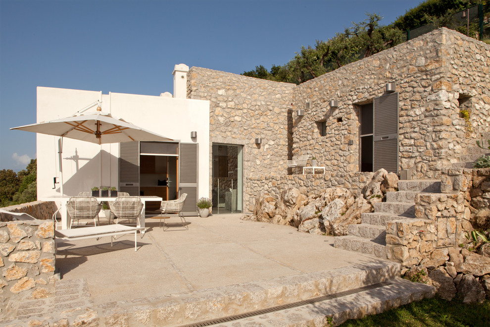 Diseño de patio mediterráneo de tamaño medio en patio lateral con toldo