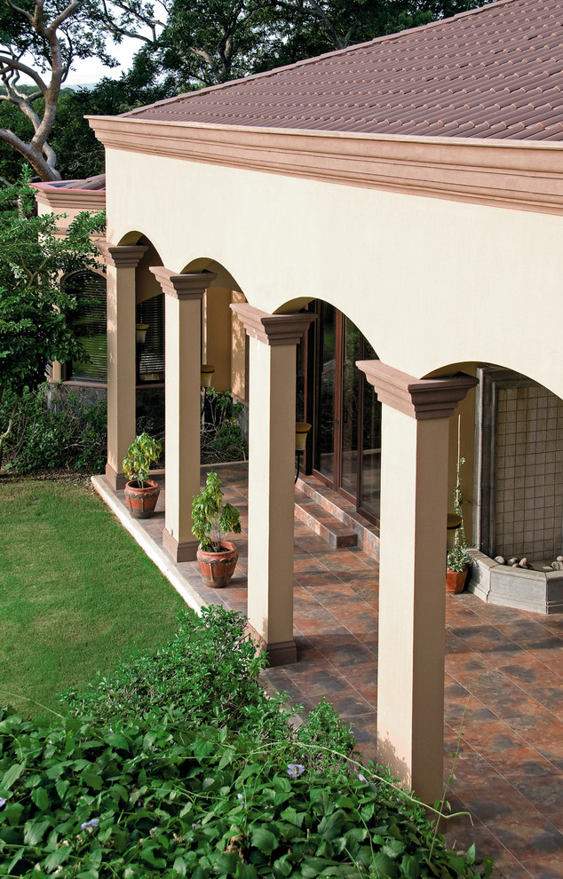 Immagine di un patio o portico mediterraneo di medie dimensioni e dietro casa con un tetto a sbalzo
