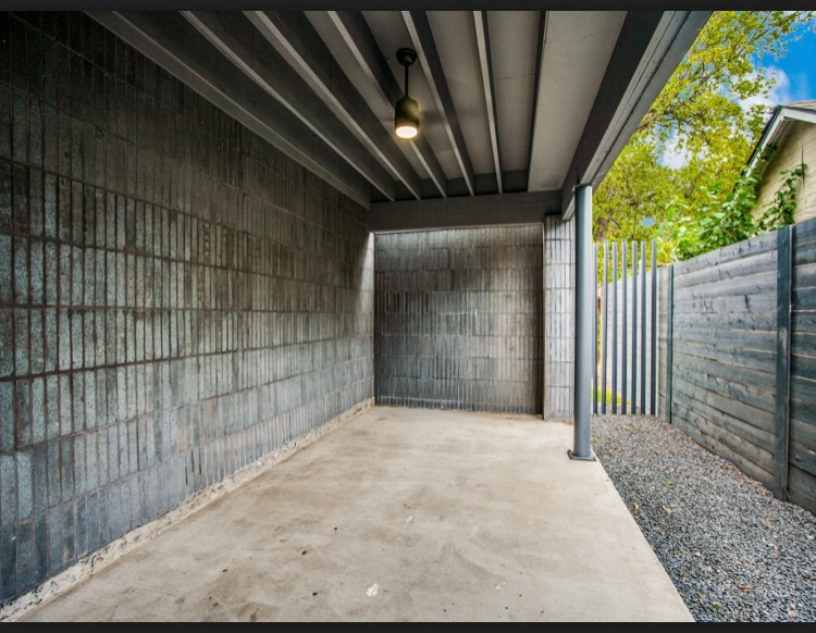 Ispirazione per un patio o portico minimalista nel cortile laterale con pavimentazioni in mattoni e un tetto a sbalzo
