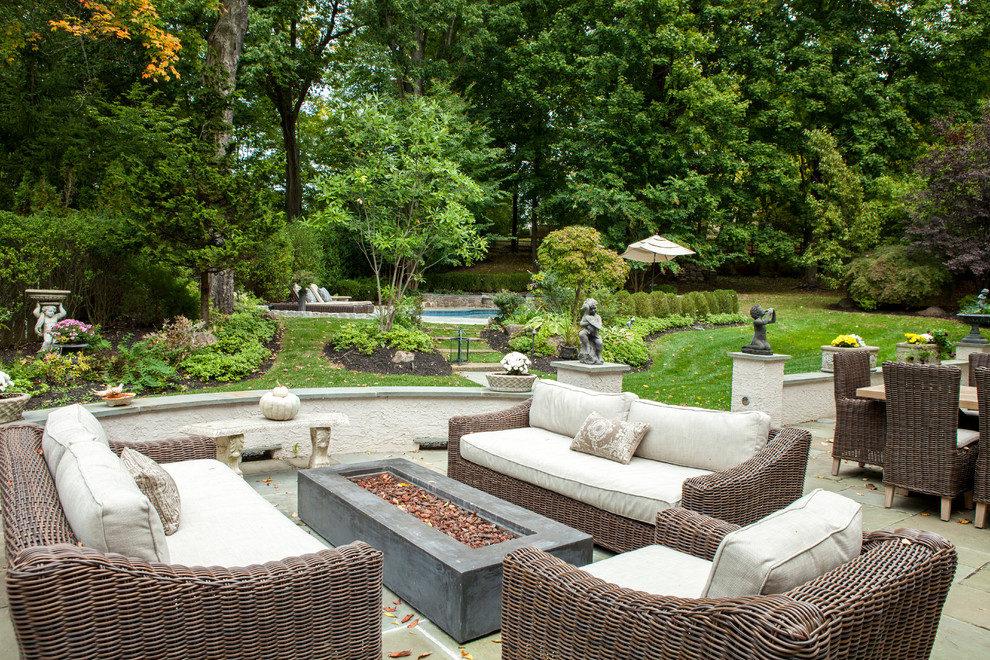 Large elegant backyard stone patio photo in Philadelphia with a fire pit