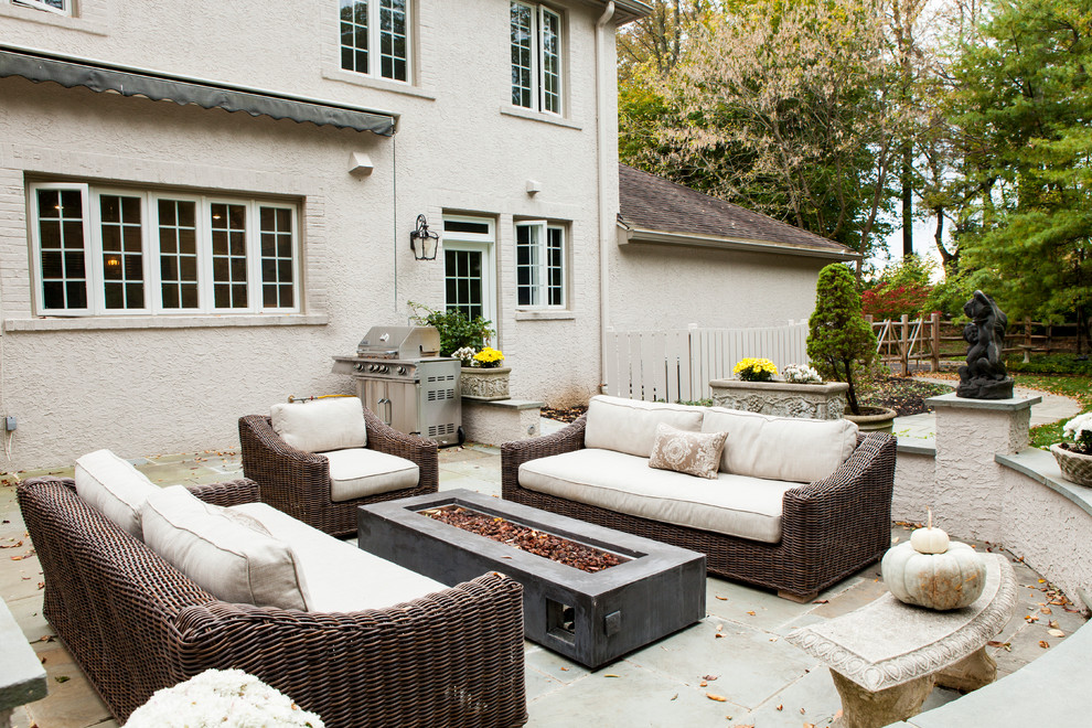 На фото: большой двор на заднем дворе в классическом стиле с покрытием из каменной брусчатки, козырьком и местом для костра с