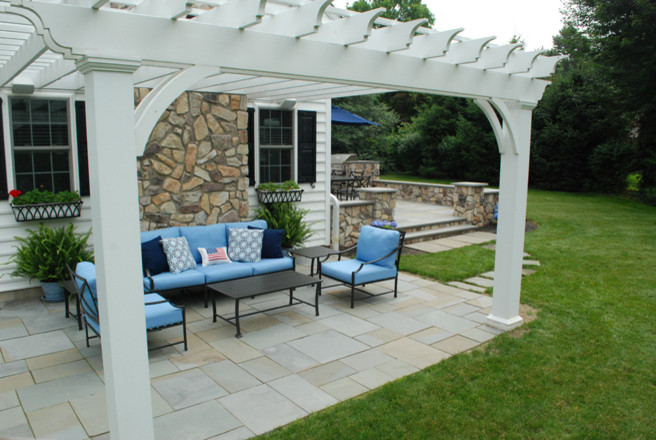Imagen de patio clásico de tamaño medio en patio con cocina exterior, adoquines de piedra natural y pérgola