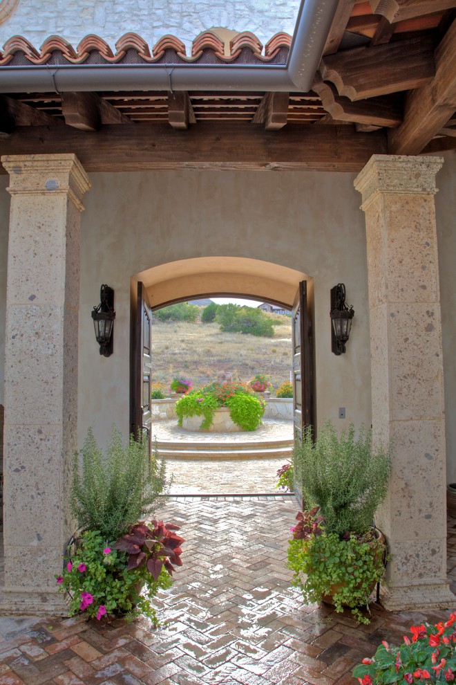 Esempio di un patio o portico mediterraneo di medie dimensioni e in cortile con pavimentazioni in mattoni e nessuna copertura
