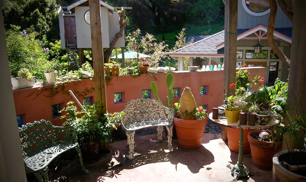 Example of a mid-sized eclectic backyard stone patio container garden design in San Francisco with a pergola
